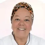 Rita Rosário, de turbante estampado e dólmã branco, sorrindo